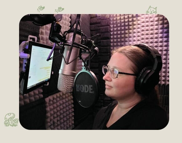 Tiffanie in her old sound booth Picture of Tiffanie in her old sound booth, reading a script. there is a microphone and a wall mounted ipad in front of her. She is wearing a black shirt, glasses and headphones